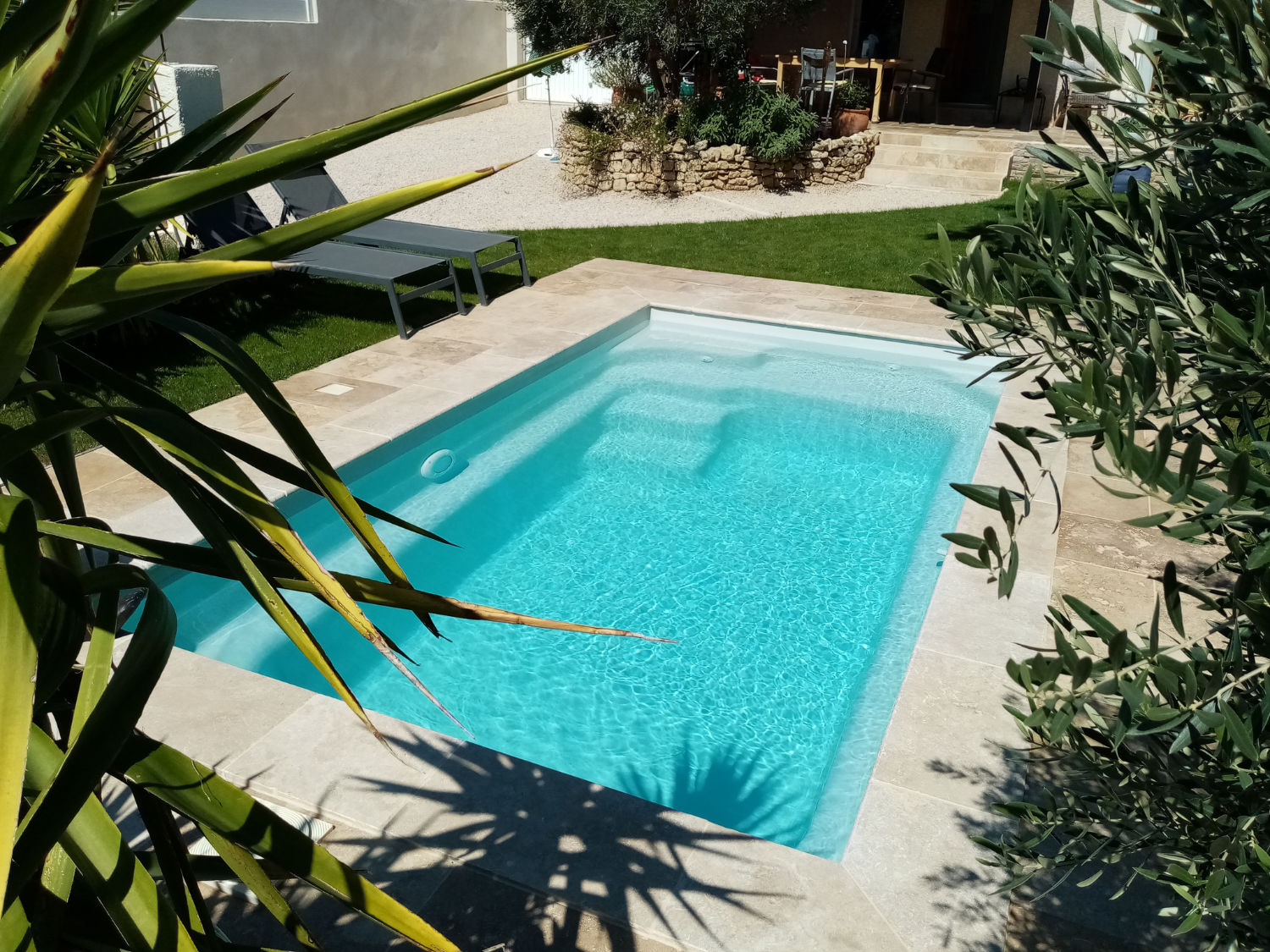 Une piscine coque installée dans un jardin